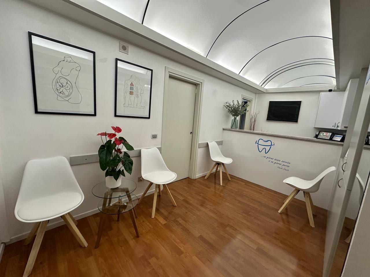 La sala d'attesa, con sedie bianche, parquet e soffitto a volta illuminato