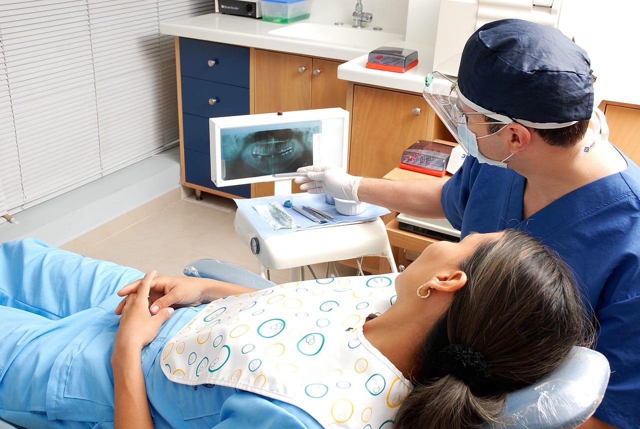 Il dentista mostra a una paziente la radiografia panoramica